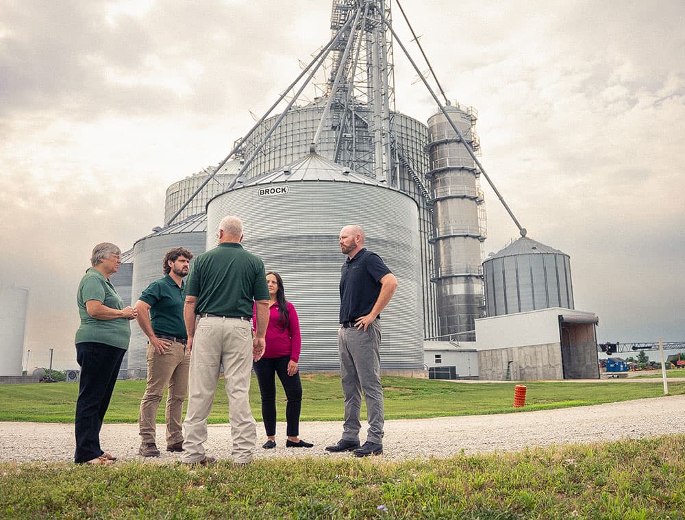 Farm-Meeting farm consultants meeting with farmers near grain bins